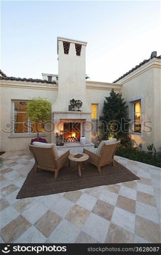Outdoor room with firepit at dusk