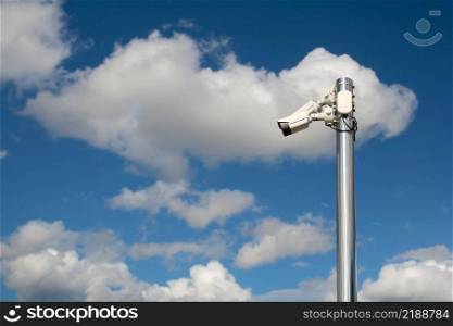 Outdoor security cctv cameras on a pole with blue cloudy sky background.. Outdoor security cctv cameras on a pole with blue cloudy sky background