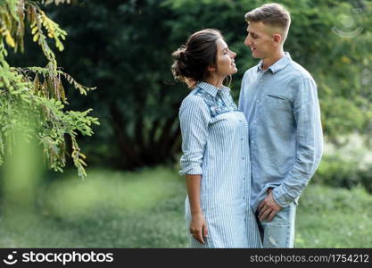 Outdoor shot of young happy couple in love on sunny day on nature. Man and woman hugging, sunlight in summer park. valentine&rsquo;s day. The concept holiday.. Outdoor shot of young happy couple in love on sunny day on nature. Man and woman hugging, sunlight in summer park. valentine&rsquo;s day. The concept holiday