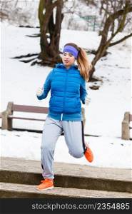 Outdoor sport exercises, sporty outfit ideas. Woman wearing warm sportswear getting ready before exercising, running jogging outside during winter.. Woman wearing sportswear exercising outside during winter