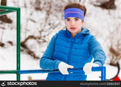 Outdoor sport exercises, sporty outfit ideas. Woman wearing warm sportswear relaxing after exercising outside during winter.. Woman wearing warm sportswear relaxing after exercising