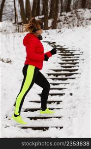 Outdoor sport exercises, sporty outfit ideas. Woman wearing warm sportswear running jogging outside during winter.. Woman wearing sportswear exercising during winter
