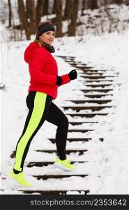 Outdoor sport exercises, sporty outfit ideas. Woman wearing warm sportswear running jogging outside during winter.. Woman wearing sportswear exercising during winter