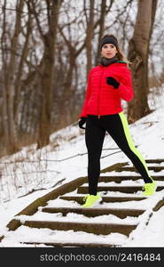 Outdoor sport exercises, sporty outfit ideas. Woman wearing warm sportswear running jogging outside during winter.. Woman wearing sportswear exercising during winter