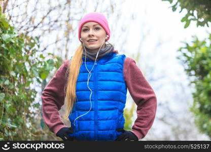 Outdoor sport exercises, sporty outfit ideas. Woman wearing warm sportswear training exercising outside during autumn, warming up before workout.. Woman wearing sportswear exercising outside during autumn