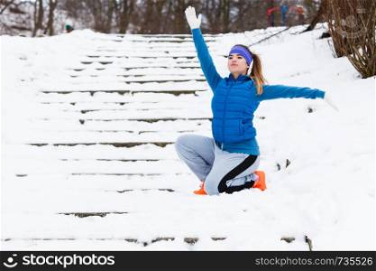 Outdoor sport exercises, sporty outfit ideas. Woman wearing warm sportswear training exercising stretching arms outside during winter.. Woman wearing sportswear exercising outside during winter