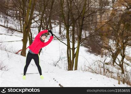 Outdoor sport exercises, sporty outfit ideas. Woman wearing warm sportswear training exercising outside during winter.. Woman wearing sportswear exercising during winter