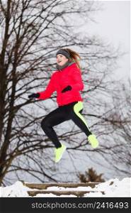 Outdoor sport exercises, sporty outfit ideas. Woman wearing warm sportswear training exercising outside during winter.. Woman wearing sportswear exercising during winter