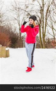 Outdoor sport exercises, sporty outfit ideas. Woman wearing warm sportswear training exercising outside during winter.. Woman wearing sportswear exercising outside during winter