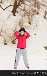 Outdoor sport exercises, sporty outfit ideas. Woman wearing warm sportswear training exercising outside during winter.. Woman wearing sportswear exercising outside during winter