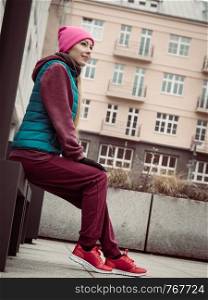 Outdoor sport exercises, sporty outfit ideas. Young woman wearing warm sportswear relaxing after workout. Sporty woman relaxing after workout