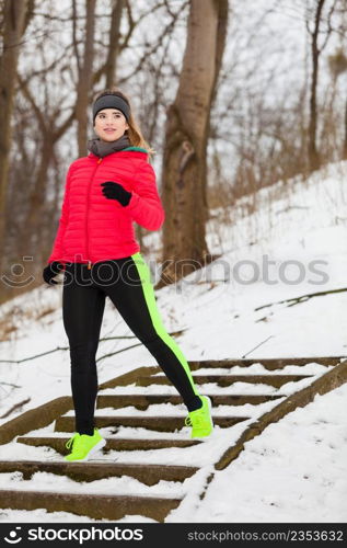 Outdoor sport exercising, sporty outfit ideas. Woman wearing warm sportswear training exercising outside during winter.. Woman wearing sportswear exercising outside during winter