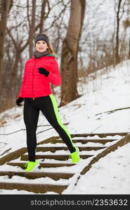 Outdoor sport exercising, sporty outfit ideas. Woman wearing warm sportswear training exercising outside during winter.. Woman wearing sportswear exercising outside during winter