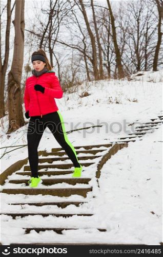 Outdoor sport exercising, sporty outfit ideas. Woman wearing warm sportswear training exercising outside during winter.. Woman wearing sportswear exercising outside during winter