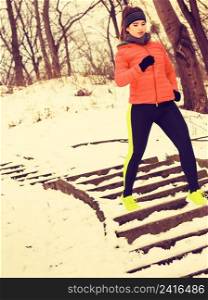 Outdoor sport exercising, sporty outfit ideas. Woman wearing warm sportswear training exercising outside during winter.. Woman wearing sportswear exercising outside during winter