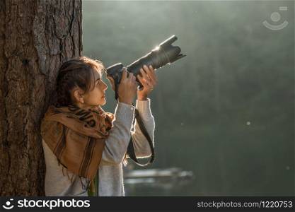 Outdoor summer lifestyle portrait of pretty woman take some photo near river in evening with camera travel of photographer Making pictures in hipster style gray cloth brown fabric sunset
