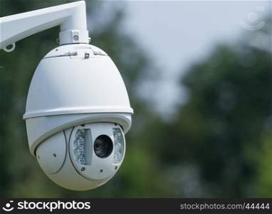 Outdoor surveillance video camera on a background of trees