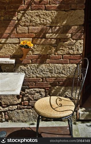 Outdoor table and chair with a brick background