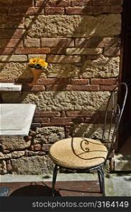 Outdoor table and chair with a brick background