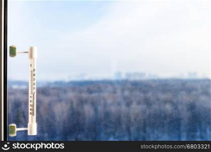 outdoor thermometer with minus 25 degrees celsius temperature on window glass in cold winter day