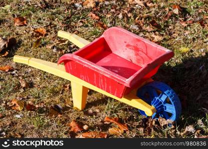 Outdoor toy, red and yellow wheelbarrow in plastic