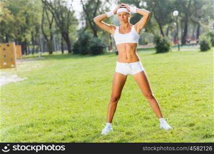 Outdoor workout. Young attractive sport girl in park working out
