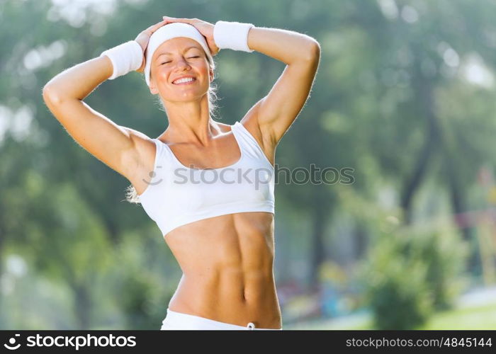 Outdoor workout. Young attractive sport girl in white sport wear in park