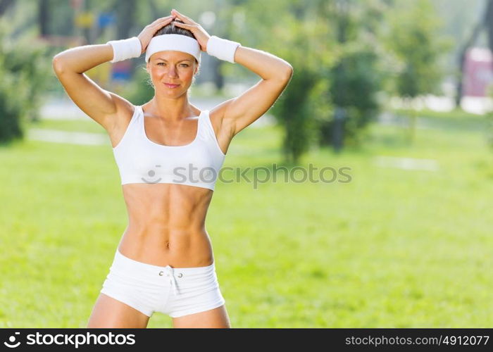 Outdoor workout. Young attractive sport girl in white sport wear in park