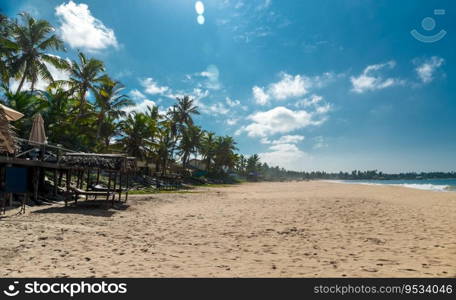 Outdoors cafe on the beach. Beautiful view on sandy coast of tropical beach resort. Gorgeous summer holidays. Sri Lanka.. Beautiful beach landscape of Sri Lanka