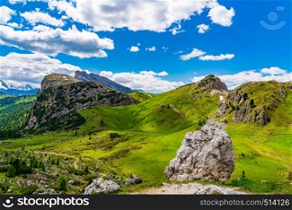 Outdoors landscape of the Dolomites mountain with the green valley and rocky hill at Falzarego Pass in Italy