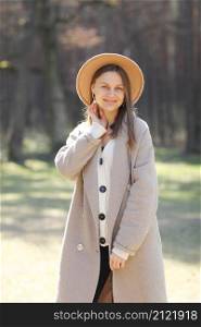 outdoors portrait of beautiful young woman wearing fashion autumn clothes on the background of good autumn day. stylish girl in hat and coat in the forest.. outdoors portrait of beautiful young woman wearing fashion autumn clothes on the background of good autumn day. stylish girl in hat and coat in the forest