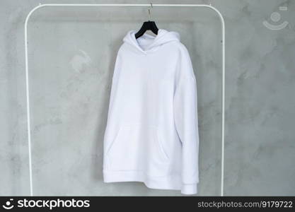 Outerwear, Closet order, White sweatshirt, Green sweater, Pink Sweatshirt, black sweater, Blue sweatshirt, Fold things, men&rsquo;s sweater, Women&rsquo;s sweatshirt, Unisex clothing, Large size, children&rsquo;s clothing. A set of mock-ups of a white hoodie ,pocket, hanging on a hanger, holding in his hands, a sweatshirt with pleats.