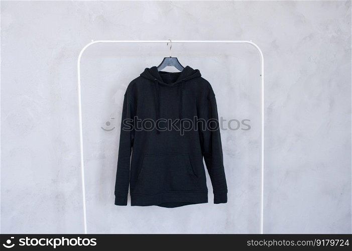 Outerwear, order in the closet, black hoodie, old things, men&rsquo;s sweater, black hoodie, Unisex clothing, large size, children&rsquo;s clothing. A set of mock-ups of a white hoodie ,pocket, hanging on a hanger, holding in his hands, a sweatshirt with pleats.
