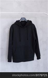 Outerwear, order in the closet, black hoodie, old things, men&rsquo;s sweater, black hoodie, Unisex clothing, large size, children&rsquo;s clothing, advertising, collaboration, marketing, place for text, layout. A set of mockups of a black hoodie with a hood and a pocket hanging on a hanger