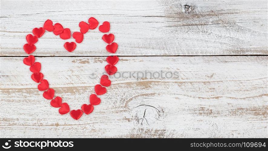 Outline of red heart shapes on rustic white wood in flat lay view