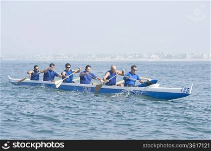 Outrigger canoeing team on water