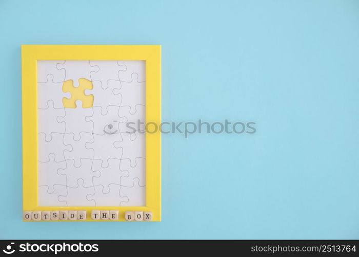 outside box puzzle yellow frame with white jig jaw pieces blue background