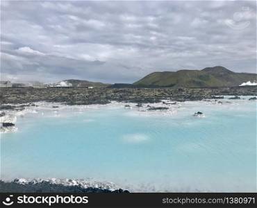 Outside the Blue Lagoon in southern Iceland, light blue water in combination with grey stones and rocks and sulfur
