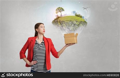 Outside the box thinking. Happy young woman in red jacket opening carton box