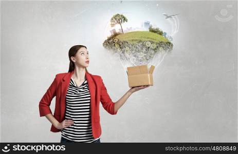 Outside the box thinking. Happy young woman in red jacket opening carton box