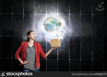 Outside the box thinking. Happy young woman in red jacket opening gift box. Elements of this image are furnished by NASA