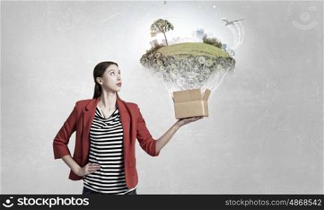 Outside the box thinking. Young woman in red jacket holding carton box in hand