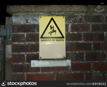 outside yellow danger of death warning sign wall; essex; england; uk