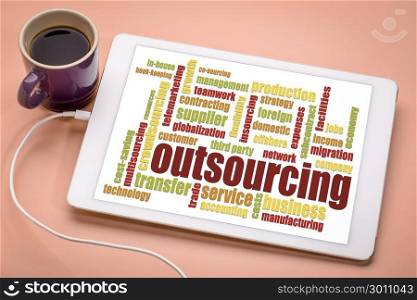 outsourcing word cloud on a digital tablet with a cup of coffee