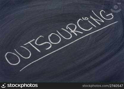 outsourcing word in white chalk handwriting on blackboard