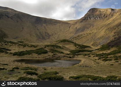 Oval lake at the foot of the mountain