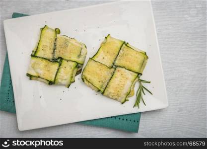 Oven baked courgettes stuffed with cheese, garlic and herbs. Courgette recipe in the oven. Top view with copy space.