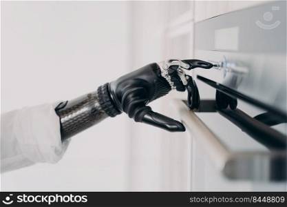 Oven opening with cyber arm grasp. Moves and touches of electronic hand. Disabled person going to cook. Amputee using high technology bionic prosthesis. Rehabilitation technology concept.. Oven opening with cyber arm prosthesis grasp. Disabled person&utee going to cook.