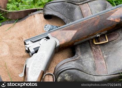 Over and under 12 bore shot gun on a cartridge bag