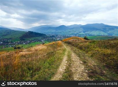Overcast autumn mountain landscape with village and country road (trans-Carpathian, Ukraine).